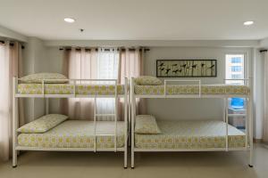 three bunk beds in a room with a window at Penthouse A Near IT Park in Cebu City +17 photos