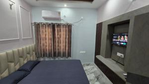 ein Schlafzimmer mit einem Bett und einem Fernseher darin in der Unterkunft Deoghar BnB in Deoghar