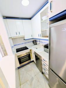 a kitchen with white cabinets and a stainless steel refrigerator at Laguna Beach 15 Primera linea de Playa in Morche