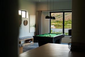 a living room with a pool table in front of a window at Kalm - Riverside living in Malgas