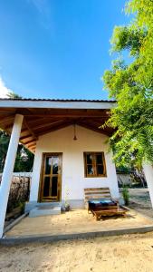 una casa con un banco delante de ella en Inara Stay, en Arugam Bay