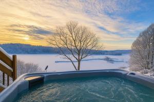 a hot tub on a balcony with a view of a lake at Waterfront Cabin - 15 Minutes from Downtown Oslo in Oslo