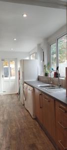 a kitchen with a white refrigerator and a dishwasher at Cheltenham town centre with parking space in Cheltenham