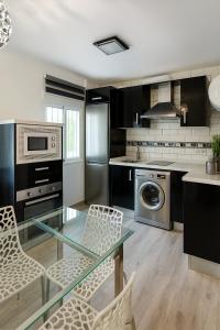 a kitchen with a glass table and chairs in it at apartamento sevilla enzo in Seville
