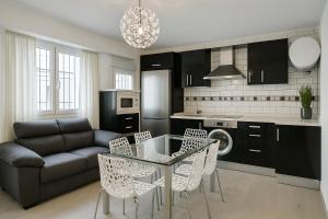 a living room with a glass table and chairs at apartamento sevilla enzo in Seville