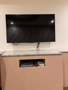 Un televisor de pantalla plana colgado en una pared en ホテル ルヴワール, en Izumi 14 fotos más