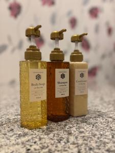 tres botellas de jabón sentadas encima de un mostrador en ホテル ルヴワール, en Izumi