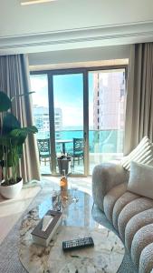 Una sala de estar con un sofá y una mesa de cristal. en King Suites Hotel, en Beirut