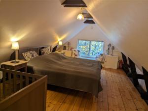 a attic bedroom with a bed and a window at Banvaktstuga anno 1905 in Fliseryd