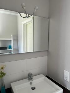 un bagno bianco con lavandino e specchio di Banvaktstuga anno 1905 a Fliseryd Altre 37 foto