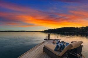 a boat on a lake with a sunset at Waterfront Cabin - 15 Minutes from Downtown Oslo in Oslo +4 photos