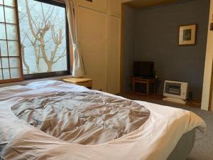 a white bed in a bedroom with a window at 釧路の夕日に近い宿トラベラーズイン南大通 in Kushiro