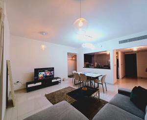 Panoramic B8 Sea View two bedroom apartment في أبوظبي: غرفة معيشة بها أريكة وطاولة