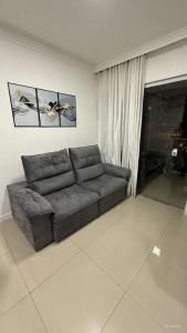 Apto 2 dormitórios Itapema في ايتابيما: غرفة معيشة مع أريكة جلدية في غرفة