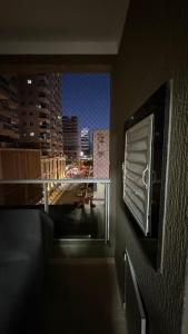 Apto 2 dormitórios Itapema في ايتابيما: غرفة بها نافذة مطلة على المدينة