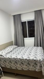 Apto 2 dormitórios Itapema في ايتابيما: سرير في غرفة نوم بها نافذة