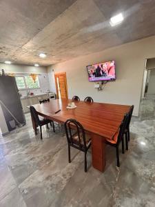 tavolo da pranzo con sedie e TV a parete di La Felicidad a Ostende