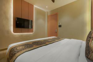 a bedroom with a bed with a television on the wall at Hotel sign inn Few Steps From Golden Temple in Amritsar