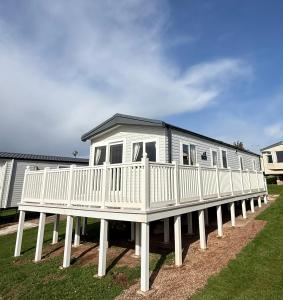 een groot wit huis op een steiger in een tuin bij Luxury 3 bed sleeps 8 caravan with sea view in Exmouth