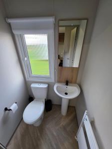 een kleine badkamer met toilet en wastafel bij Luxury 3 bed sleeps 8 caravan with sea view in Exmouth