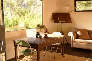 a living room with a wooden table and a couch at Serene Cabin in a Private Forest in Sedgefield +4 photos