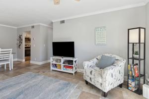 a living room with a chair and a flat screen tv at Tranquil Beach Retreat - Fernandina Shores 6398 in Fernandina Beach