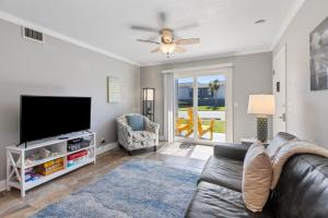 a living room with a couch and a flat screen tv at Tranquil Beach Retreat - Fernandina Shores 6398 in Fernandina Beach