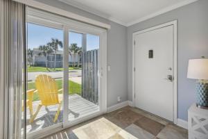 a room with a sliding glass door and a yellow chair at Tranquil Beach Retreat - Fernandina Shores 6398 in Fernandina Beach +39 photos