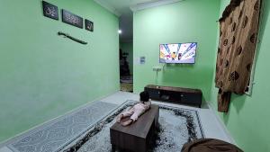 a small child sitting on a bench in a room at The Nook Housestay in Ketereh