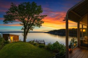 a view of a lake at sunset from a house at Waterfront Cabin - 15 Minutes from Downtown Oslo in Oslo