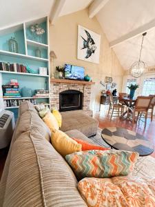 een woonkamer met een bank en een open haard bij Fins Up Margaritaville 2BD3BALoftGrillFirepit in Damsel