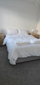 NewTown Home Host 4-5 Guests في Brettell Lane: غرفة نوم بها سرير مع ملاءات ووسائد بيضاء
