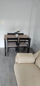 NewTown Home Host 4-5 Guests في Brettell Lane: طاولة طعام ومقعد مع طاولة وزهور