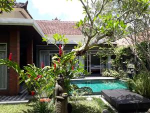 a villa with a swimming pool in a garden at Villa Ketut Kartika in Ubud