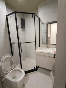 een badkamer met een douche, een toilet en een wastafel bij Jian DaoBao in Phnom Penh +10 foto's