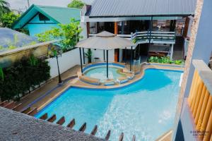 - une vue sur la piscine avec un parasol dans l'établissement 8 Diamonds Escapes, à Calamba 10 autres photos