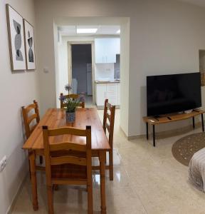 Un comedor con mesa y sillas y un televisor. en Casa Alan, en Burriana
