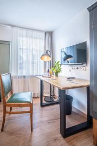 een bureau in een kamer met een stoel en een televisie bij Altes Rathaus in Schwaigern