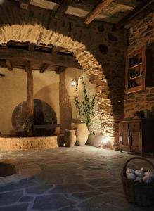 Borgo del Canto - Traditional Country Retreat - 30 Min from the Sea! في Borghetto dʼArroscia: غرفة ذات جدار حجري بها مزهريات وسلة