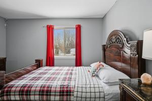 ein Schlafzimmer mit einem Bett mit roten Vorhängen und einem Fenster in der Unterkunft Bright 4BR Near MSU & Downtown home in Packard
