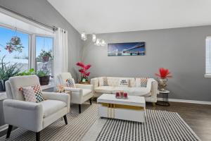 ein Wohnzimmer mit weißen Möbeln und einem großen Fenster in der Unterkunft Bright 4BR Near MSU & Downtown home in Packard + 31 Fotos