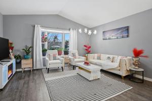 ein Wohnzimmer mit weißen Möbeln und einem Fernseher in der Unterkunft Bright 4BR Near MSU & Downtown home in Packard