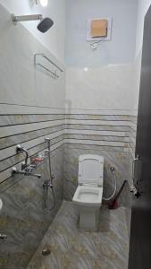 ein Badezimmer mit Toilette und Dusche in der Unterkunft Deoghar BnB in Deoghar