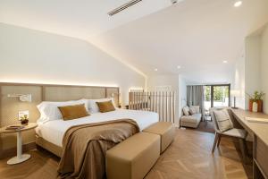 a bedroom with a large bed and a desk at Hotel Encinar de Sotogrande in Sotogrande