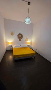 a bedroom with a yellow bed and two lights at Villa Fatjo in Le Tampon