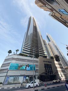 ドバイにあるDubai Marina Modern 1 Bedroom Apartment - steps to tram & Marina Walkの前に看板がある高い建物 +24枚の写真