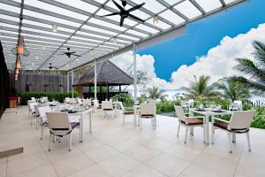 uma área de refeições com mesas e cadeiras brancas em Gaya Island Resort, Kota Kinabalu - a Small Luxury Hotels of the World em Gaya Island