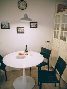 a white table with chairs and a clock on the wall at 2 bedroom large modern apartment in Blanes Old Town 50m from the beach! in Blanes