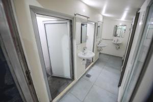 a bathroom with two sinks and a shower at Lebanon Hostel in Makhāḑat Nahr al Kalb +11 photos
