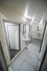 a bathroom with a sink and a shower and a mirror at Lebanon Hostel in Makhāḑat Nahr al Kalb